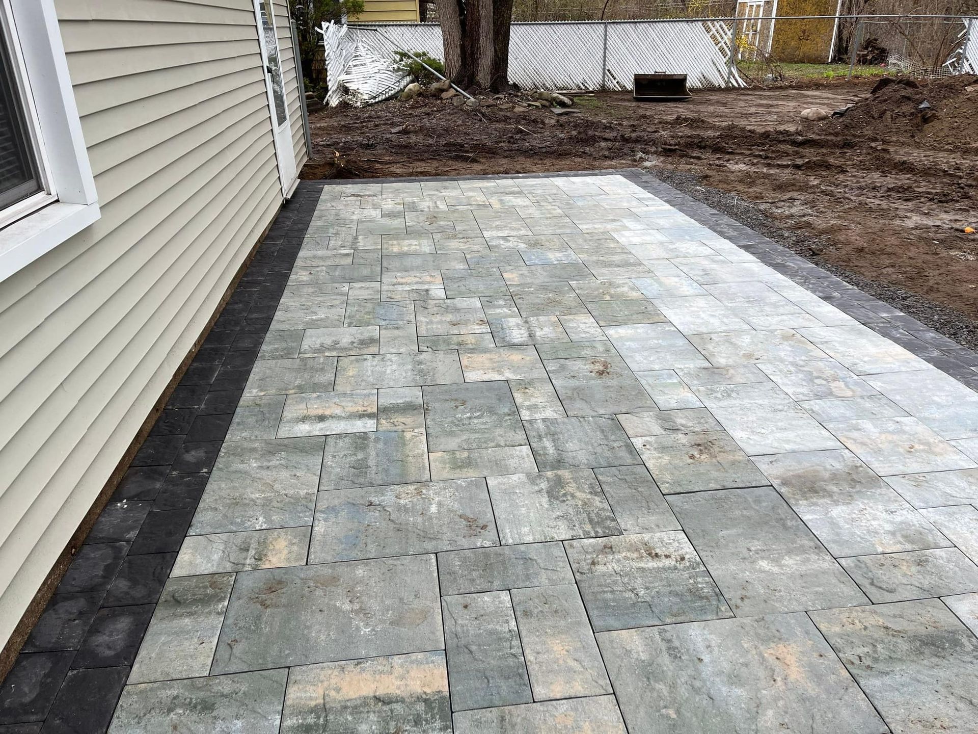 A brick walkway is being built in front of a house.