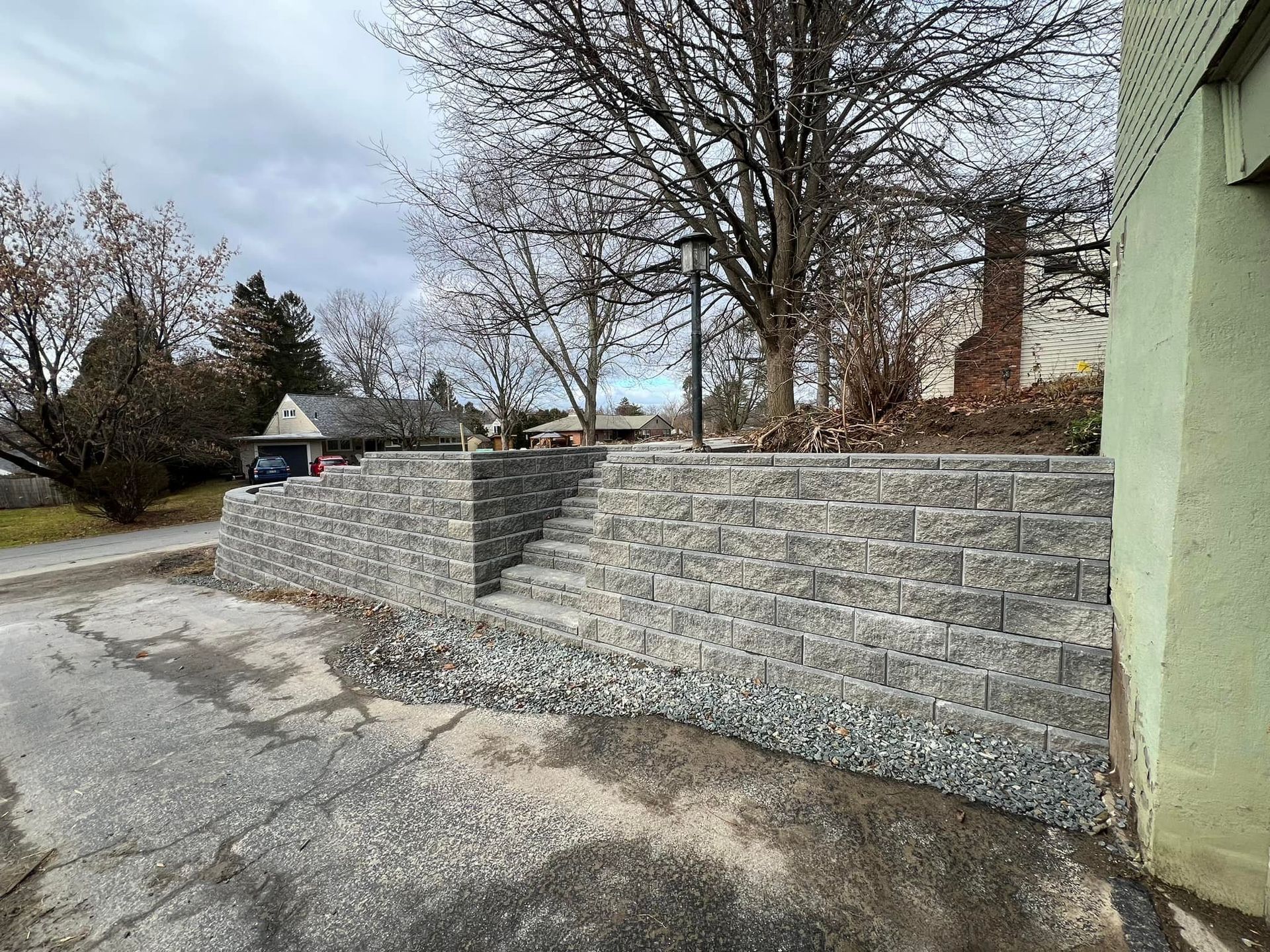 A stone wall with stairs leading up to a house.
