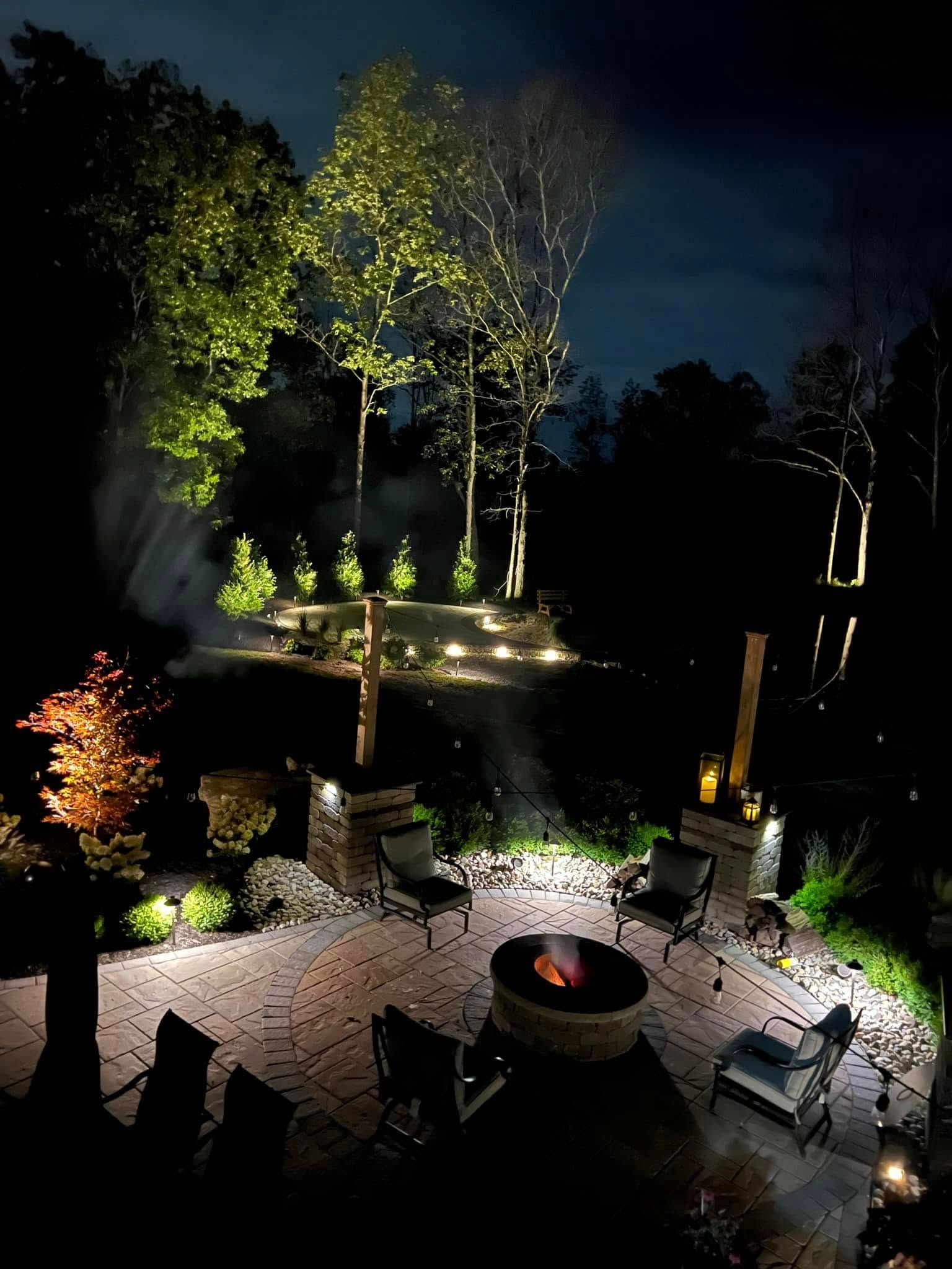 There is a fire pit in the middle of the backyard at night.