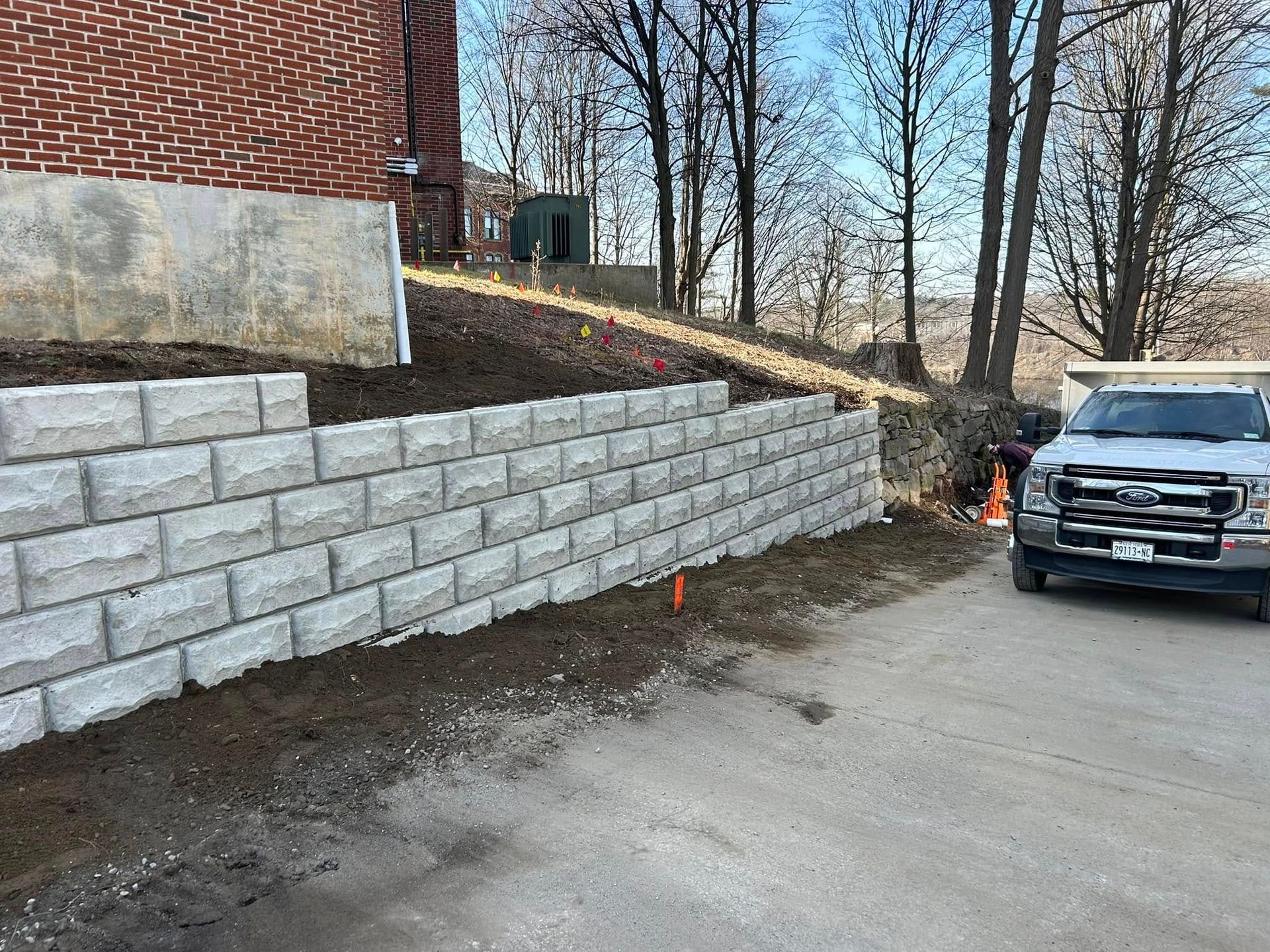 A truck is parked in front of a brick wall.