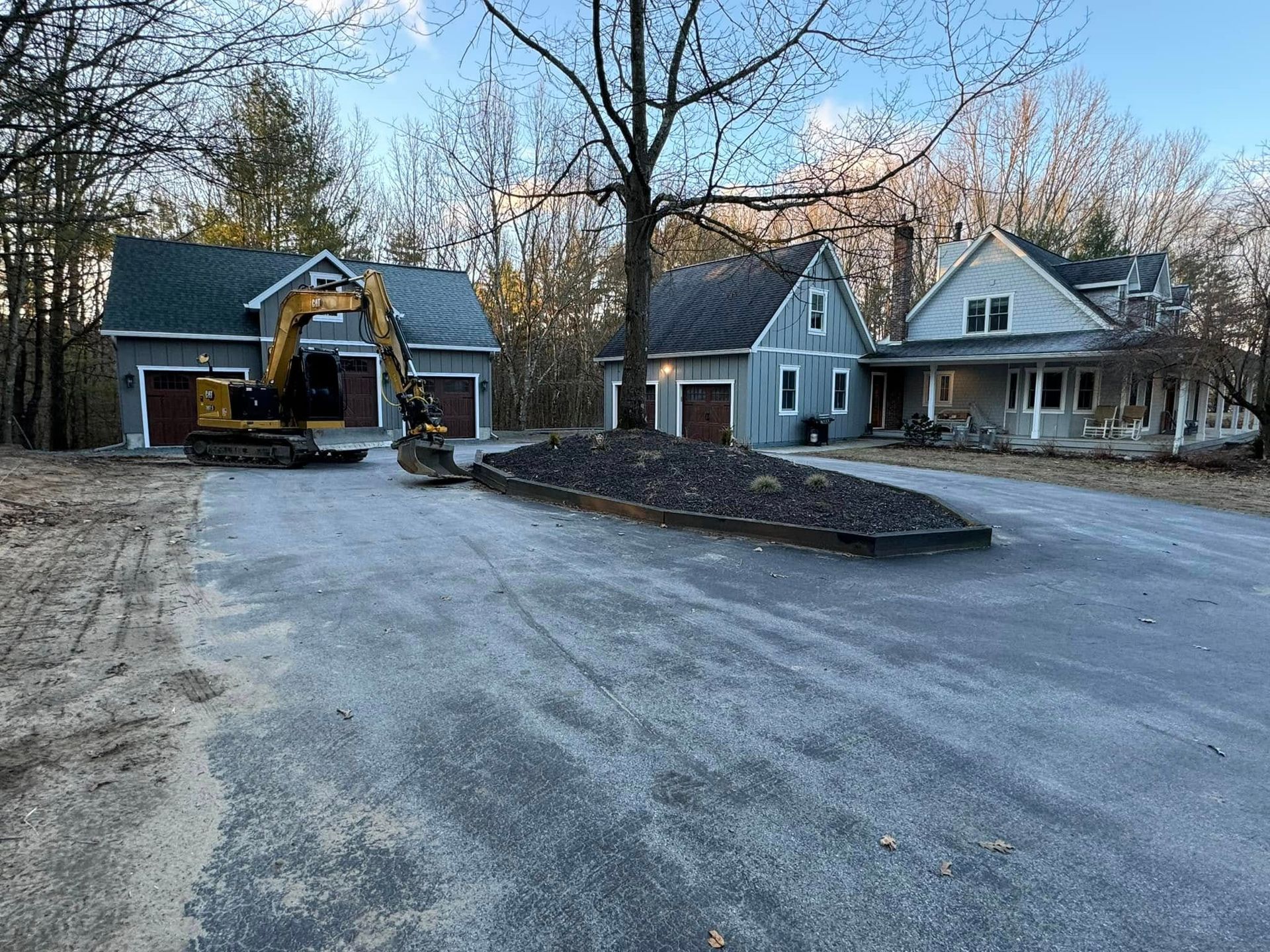 A yellow excavator is parked in front of a house.