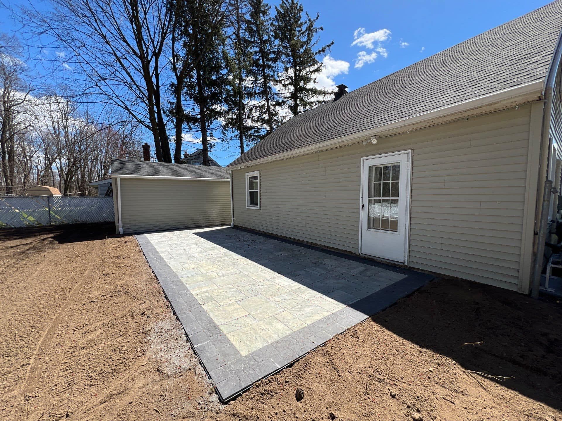 A house with a garage and a patio in front of it.