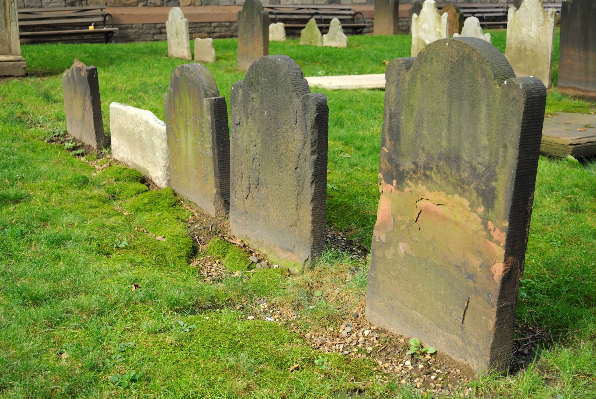 Image depicts an unmarked grave with up to 10 unmarked headstones.