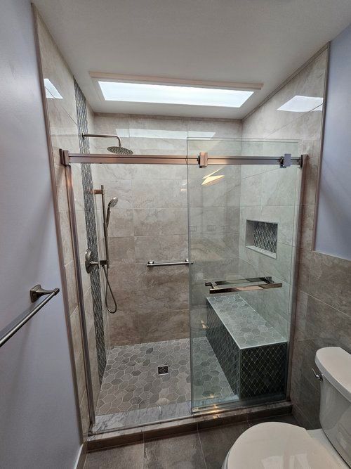 A bathroom with a walk in shower and a toilet.