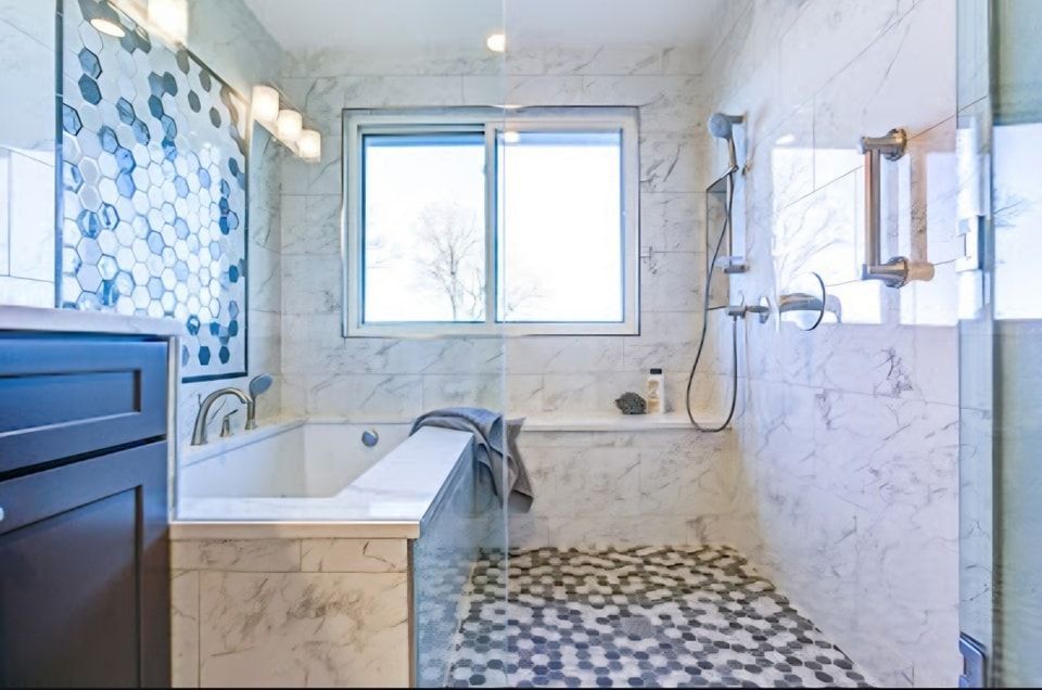 A bathroom with a tub , sink , shower and window.