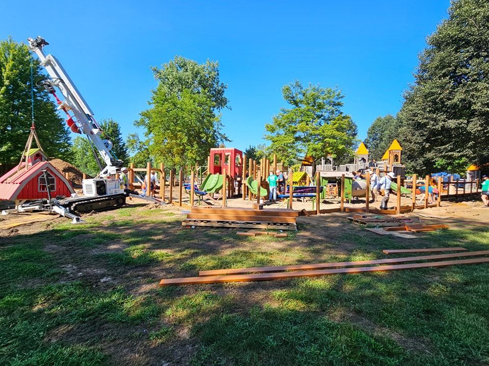 A crane is being used to build a playground in a park.