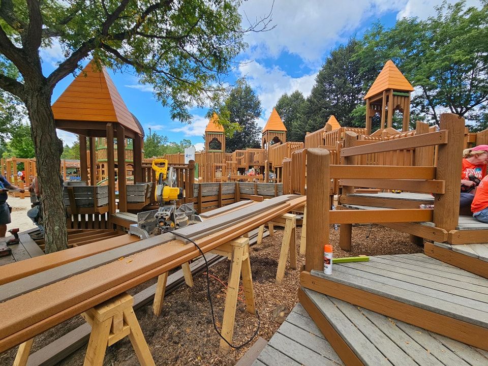 A wooden playground is being built in a park.