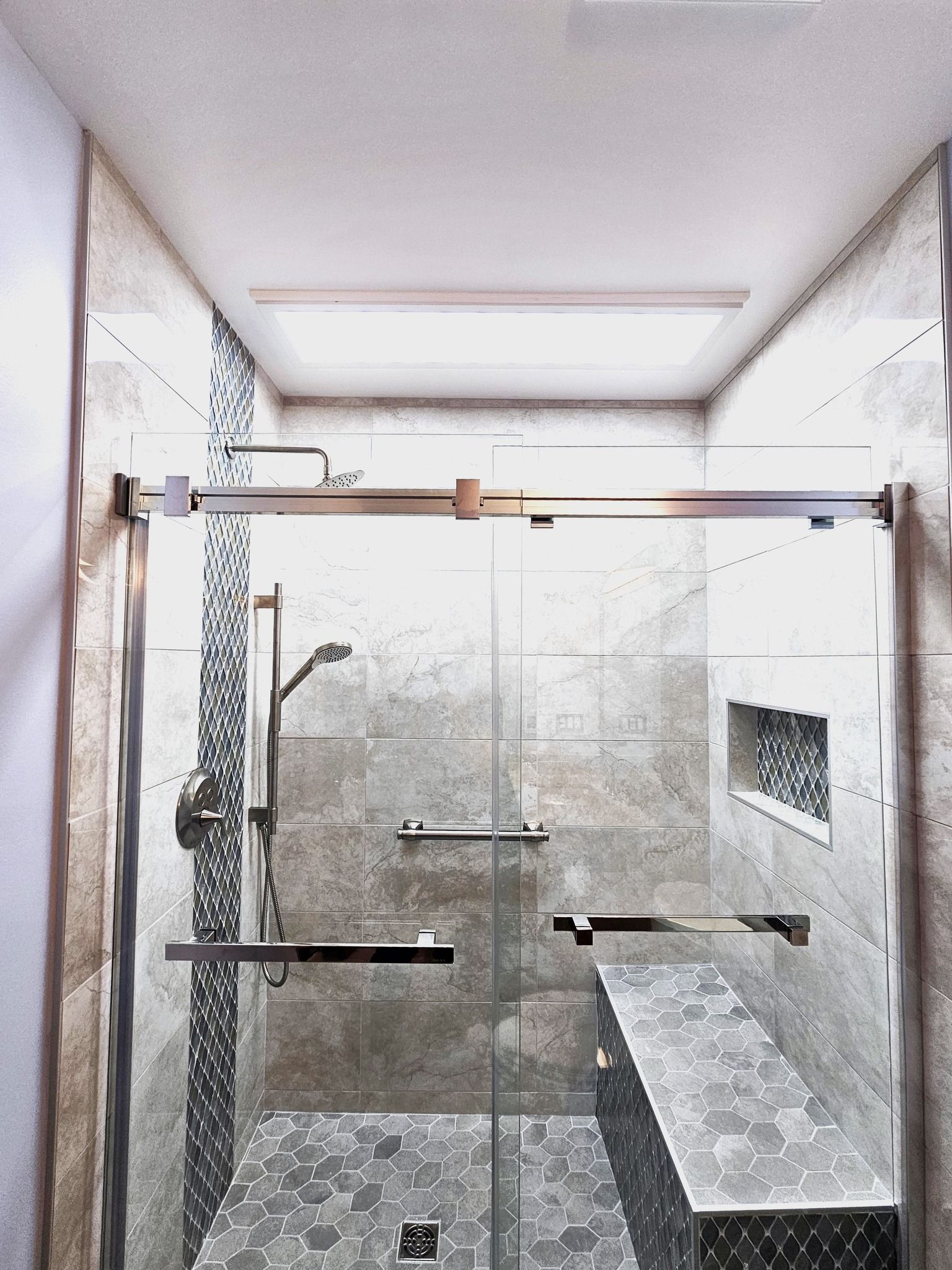 A bathroom with a sliding glass shower door