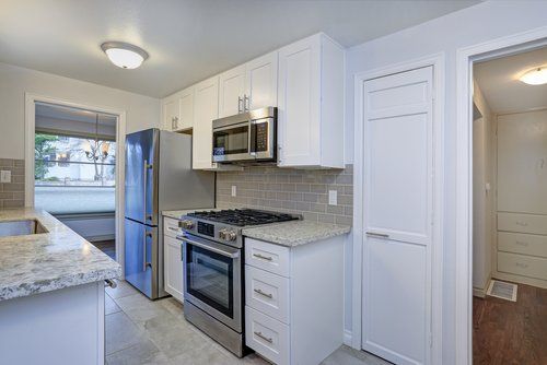 A kitchen with white cabinets and stainless steel appliances.