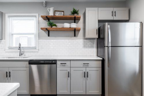 A kitchen with stainless steel appliances and white cabinets.