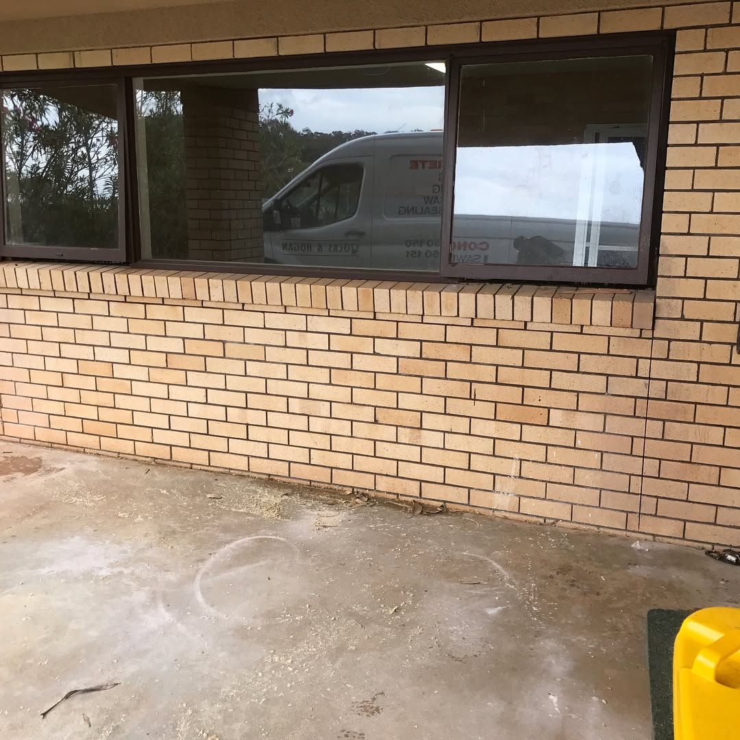 A Brick Wall With a Window and a Van in the Window — Swift Glass & Aluminium In Yamba, NSW