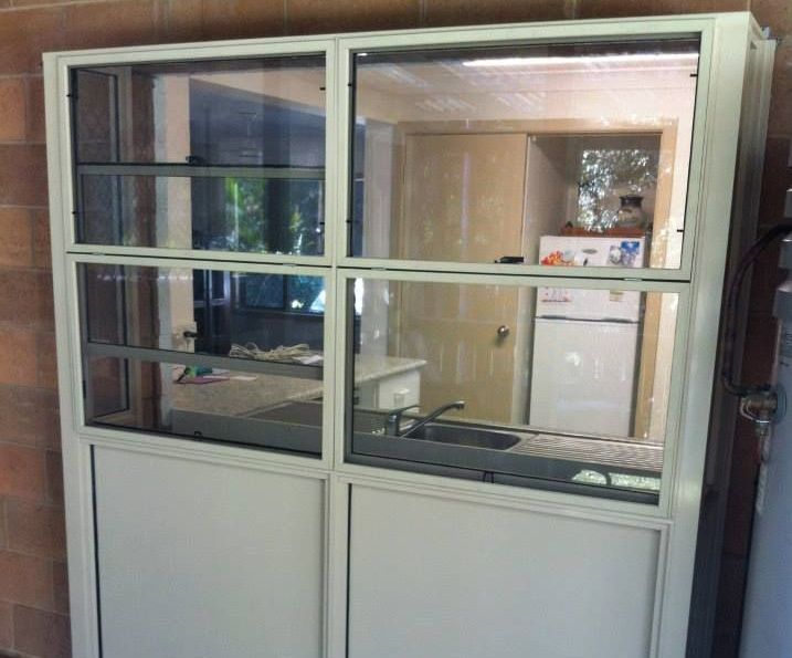 A White Cabinet With a Lot of Glass Doors in a Kitchen — Swift Glass & Aluminium In Woolgoolga, NSW