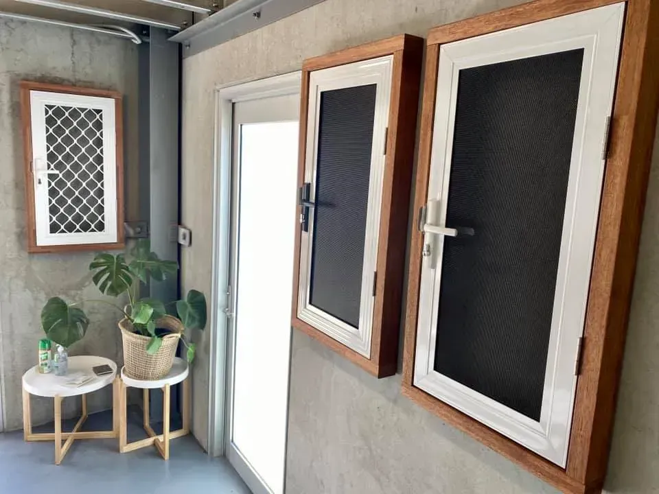 Three Screened in Windows Are Hanging on a Wall Next to a Door — Swift Glass & Aluminium In Woolgoolga, NSW