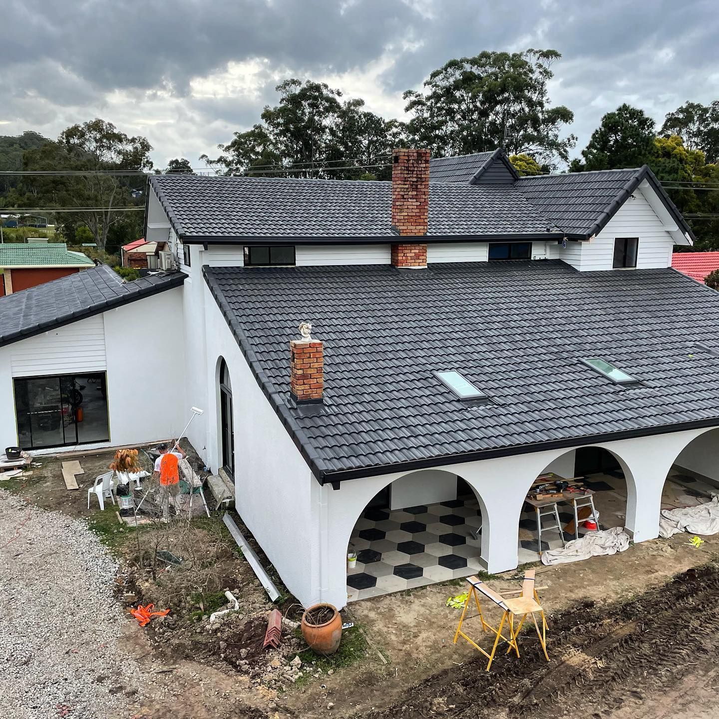A White House With Dark Gray Tiled Roof, Arched Porch, and Two Brick Chimneys — All Coast Painting in Tweed Heads South, NSW