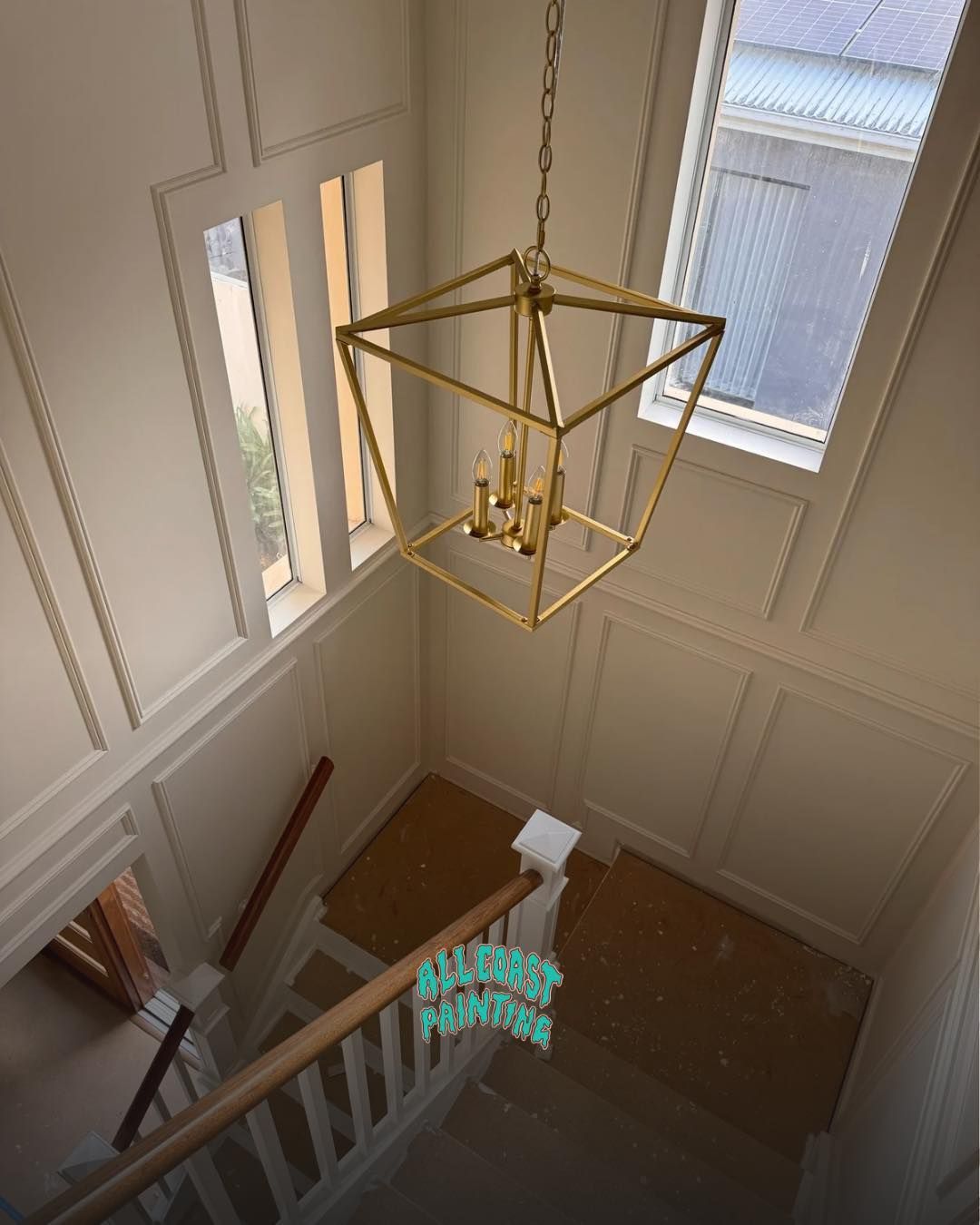 Interior view: three rectangular skylights in a white ceiling, surrounded by windows.