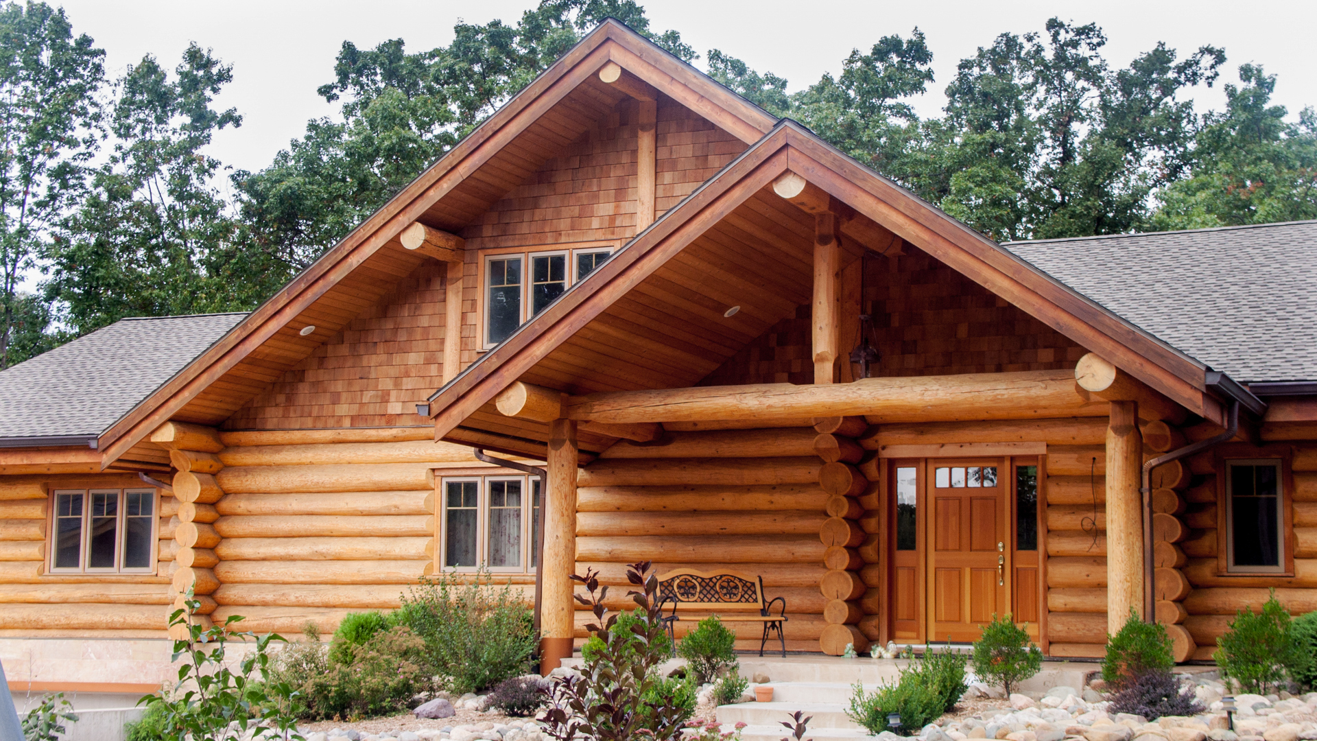 Two storey log cottage featuring complementary cedar shingles and other  exterior finishes.