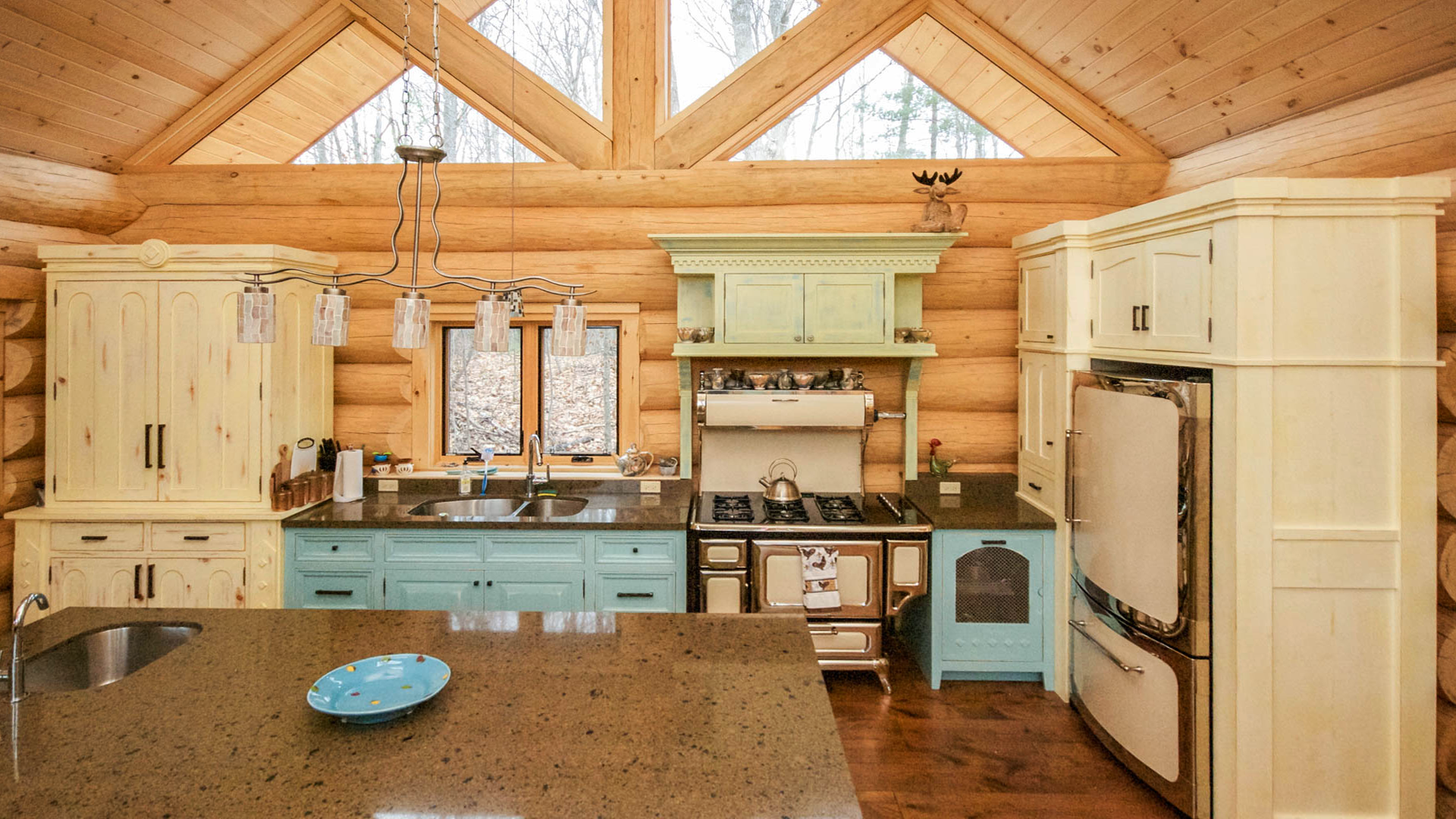 Log cabin style kitchen with antique appliances in a winter setting in Muskoka.