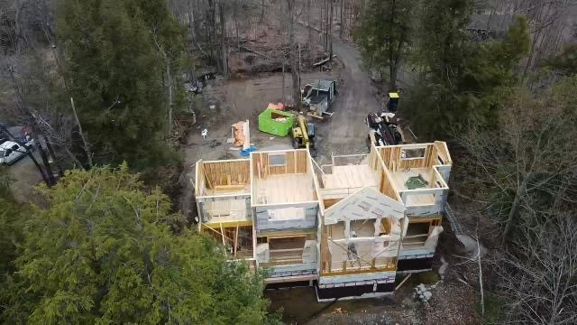 Overhead view of a family cottage being constructied in the woods.