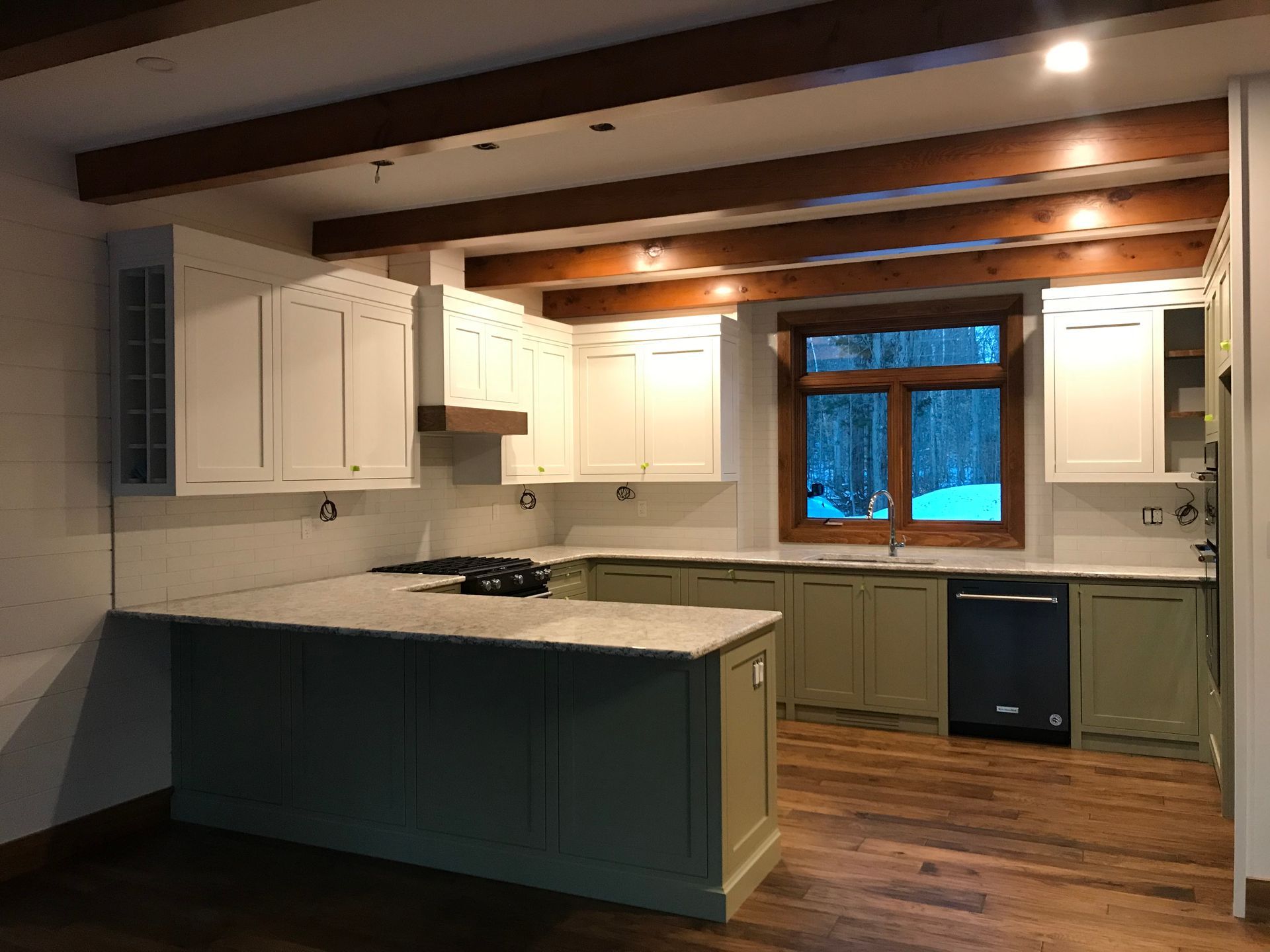 Almost finished kitchen showing ceiling beams and ample counter space.