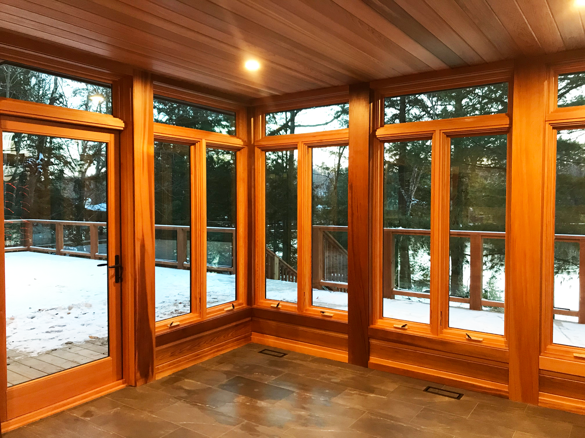 Inside the uncompleted Muskoka Room showing wood ceilings, floors and  window fixtures.