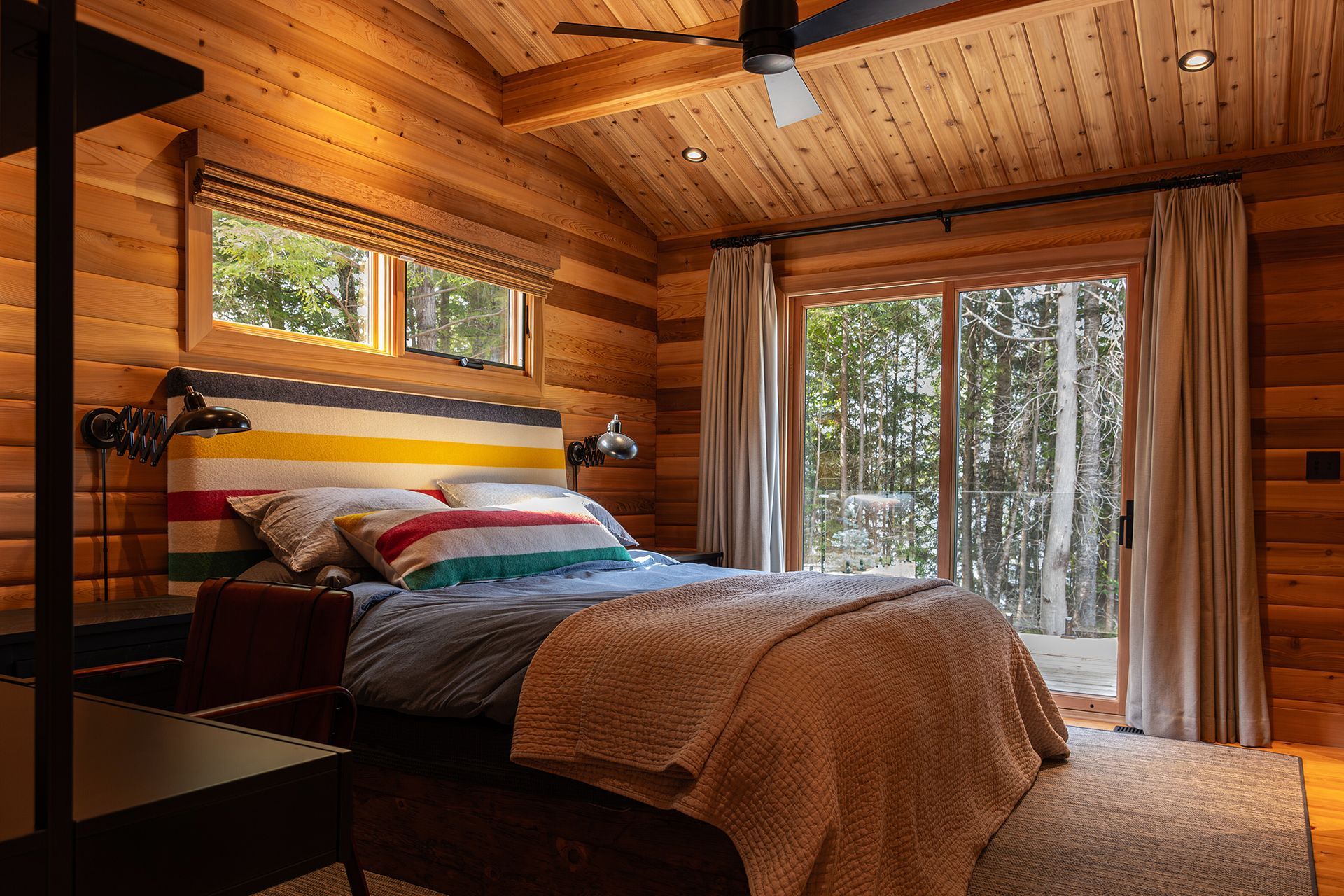 Bedroom of cedar cottage with walk out to the adjacent forest.
