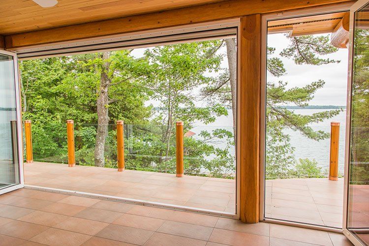 Custom Muskoka Cottage featuring a  room with a view of a lake through a sliding glass door.