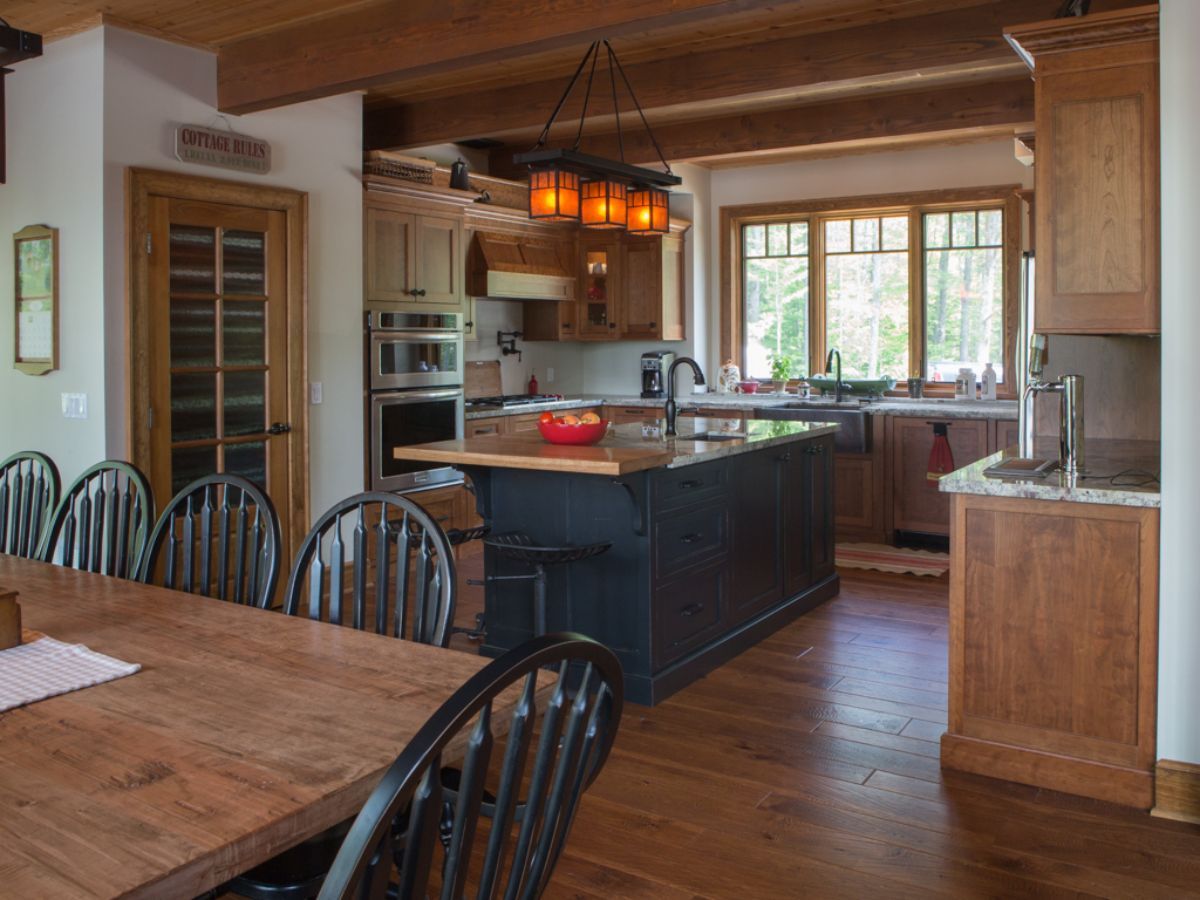 Custom Muskoka Cottage featuring a  kitchen with a large island and a wooden table and chairs