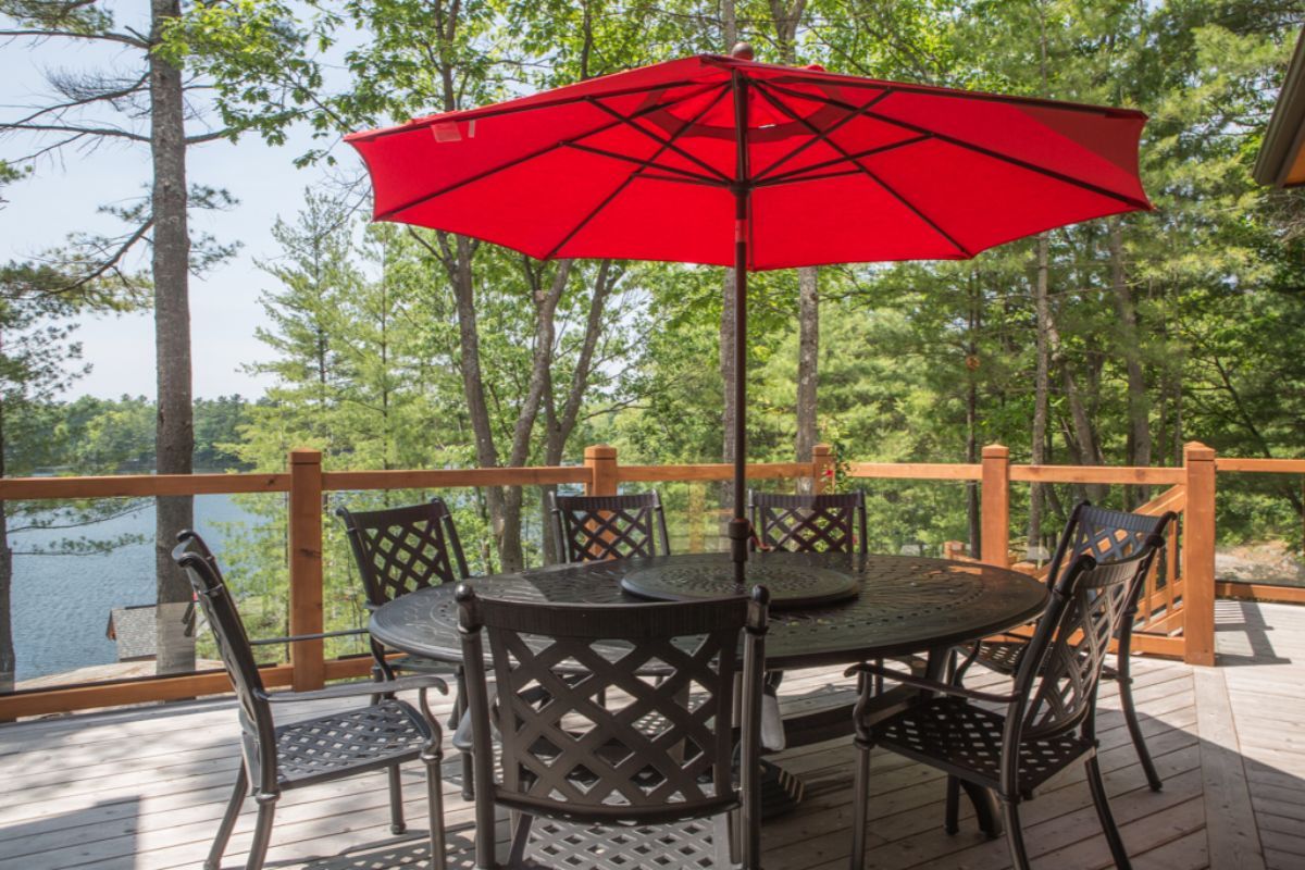 Custom Muskoka Cottage featuring a  table and chairs on a deck with a red umbrella