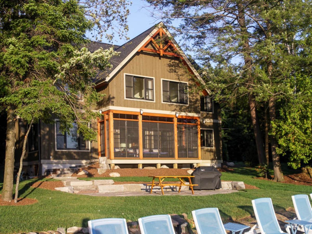 Custom Muskoka Cottage featuring a  house with a screened in porch and a picnic table