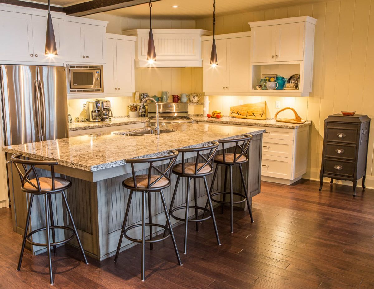 Custom Muskoka Cottage featuring a  kitchen with a large island , stools and a refrigerator.