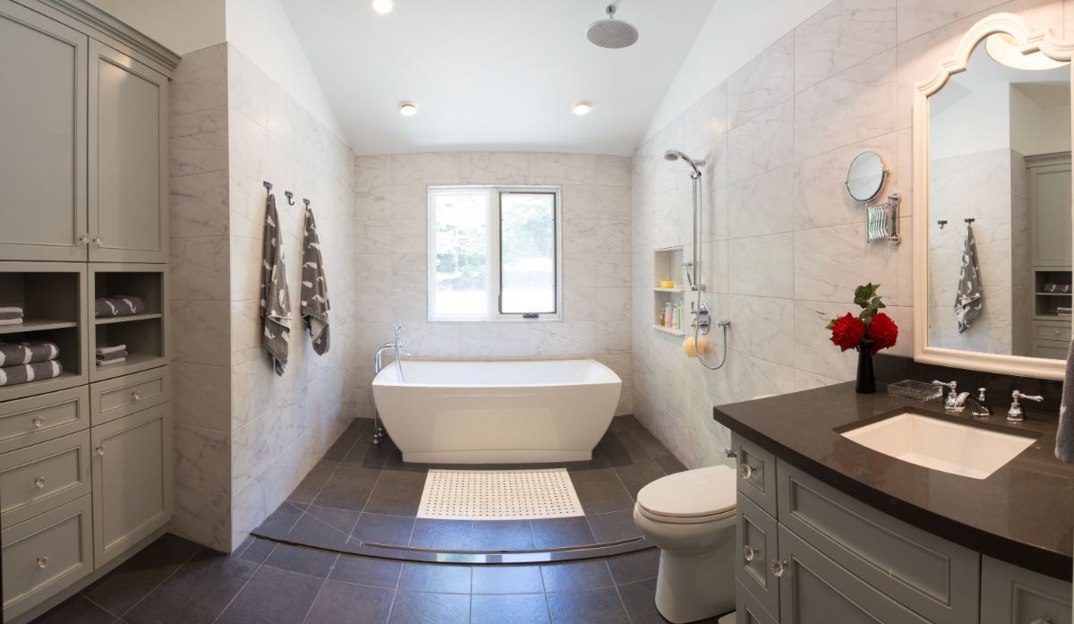 Custom Muskoka Cottage featuring a  bathroom with a tub , toilet , sink and mirror.
