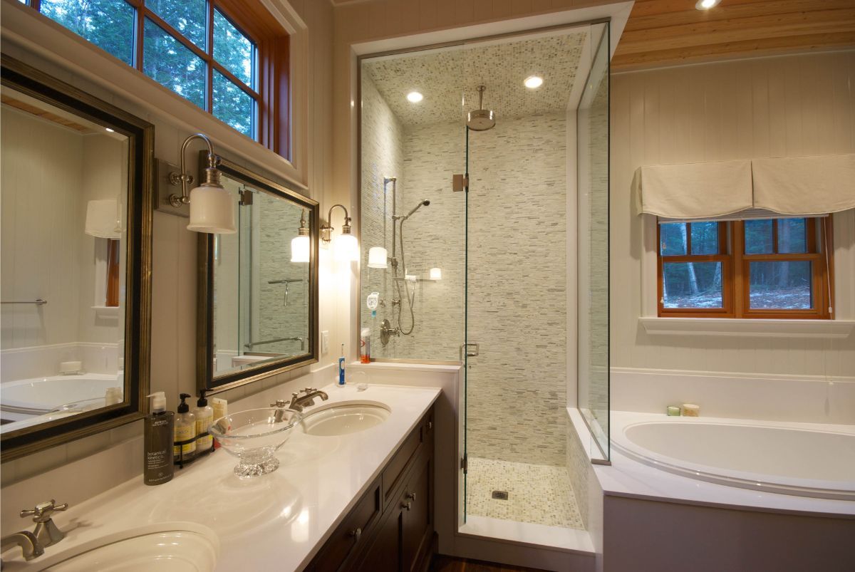 Custom Muskoka Cottage featuring a  bathroom with two sinks , a tub , and a walk in shower.