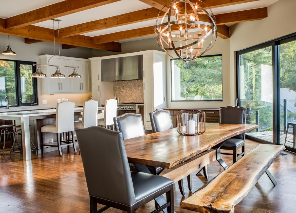 Custom Muskoka Cottage featuring a  dining room with a wooden table and chairs and a bench.