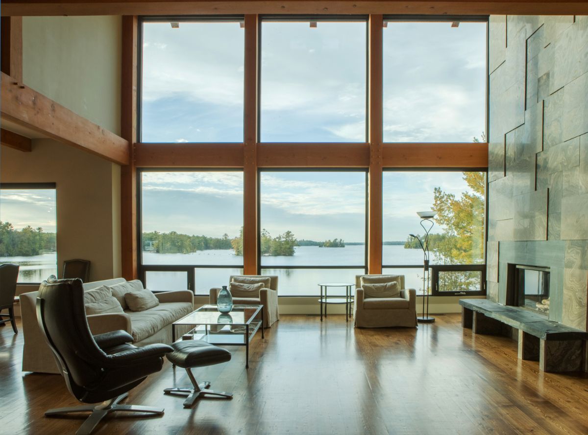 Custom Muskoka Cottage featuring a 
 living room with a lot of windows and a view of a lake