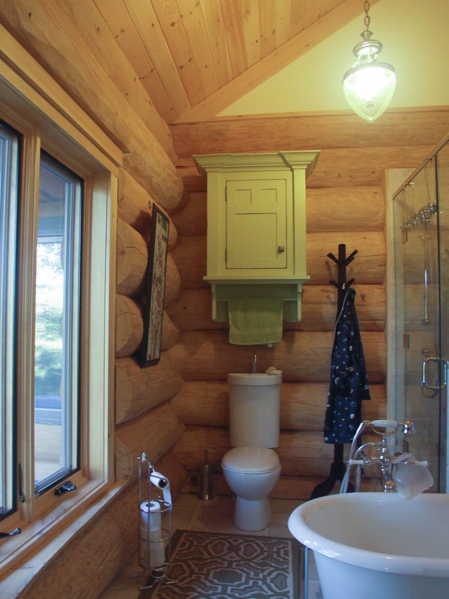 Custom Muskoka Cottage featuring a  bathroom in a log cabin with a toilet and tub