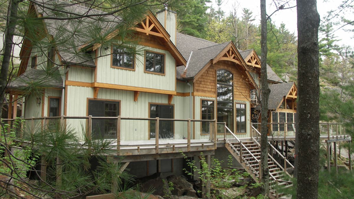 Custom Muskoka Cottage featuring a  large house in the middle of a forest