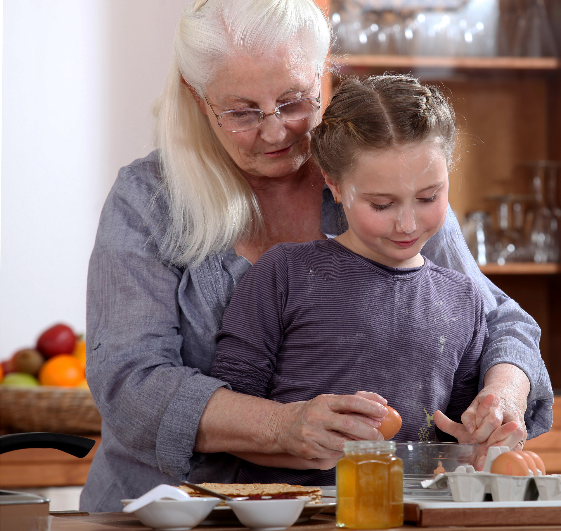 Grandma shows her young granddaughter the way to cook properly..