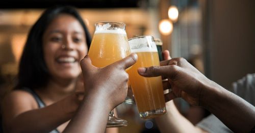 A group of people are toasting with glasses of beer.