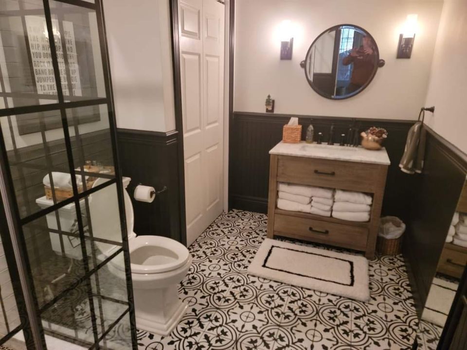 A bathroom with a toilet a sink and a mirror