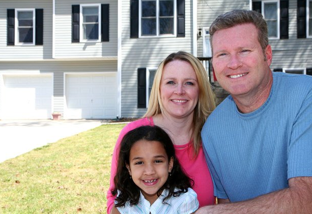Mother and father posing with their daughter