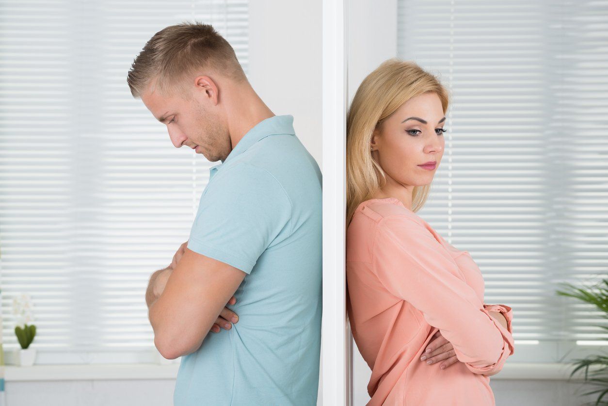 A man and a woman are divided by a wall between them.