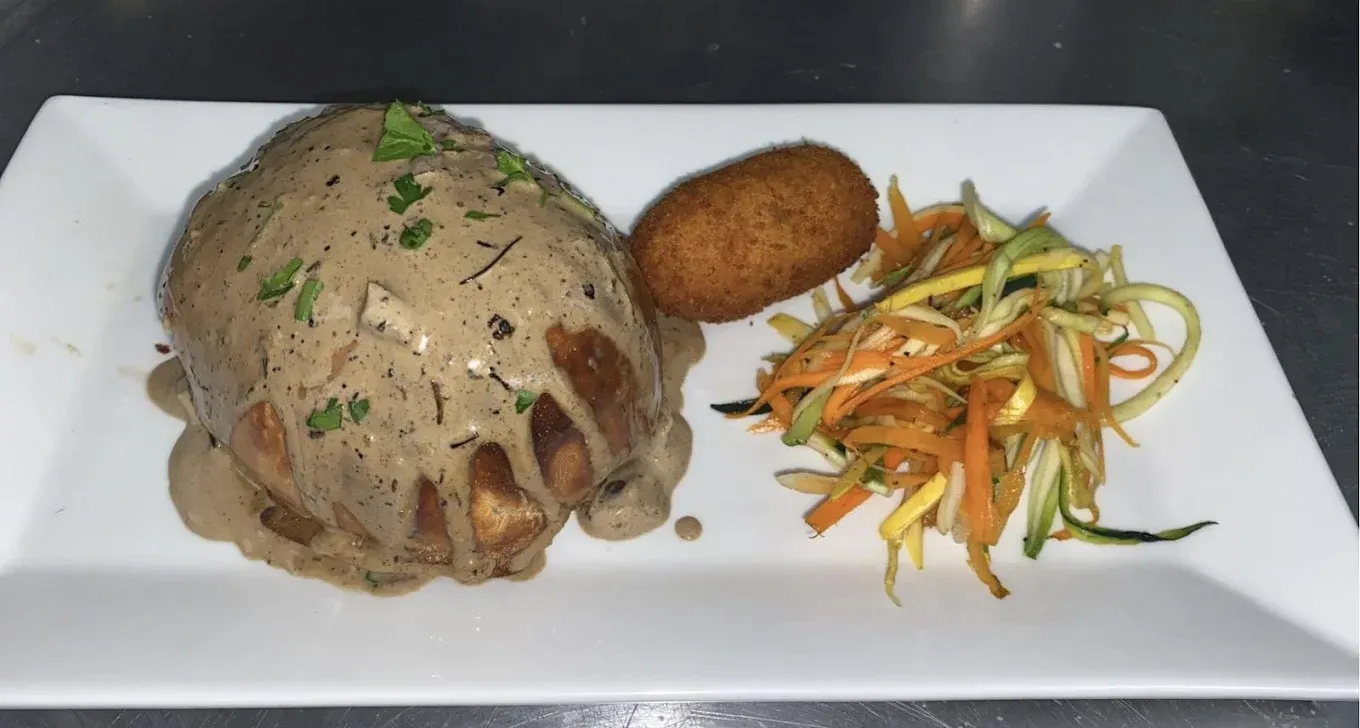 Plate of food: Chicken, mushroom sauce, croquette, julienned vegetables.