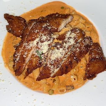 Pasta dish with breaded chicken cutlets, creamy orange sauce, and grated cheese.