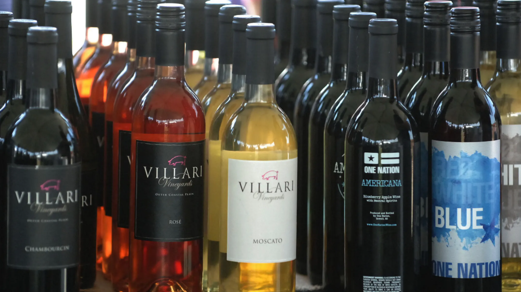 Bottles of wine, varying colors, displayed in a row.