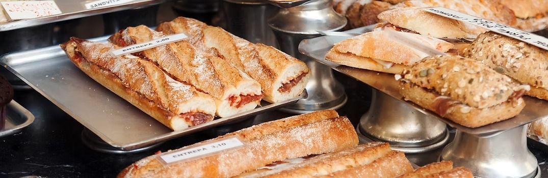Display of assorted breads in a bakery setting.