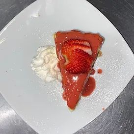 Slice of strawberry cake with strawberry glaze, whipped cream on a white plate.