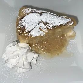 Apple dessert slice with whipped cream and powdered sugar.