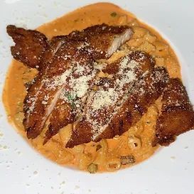 Pasta dish with breaded chicken and grated cheese.