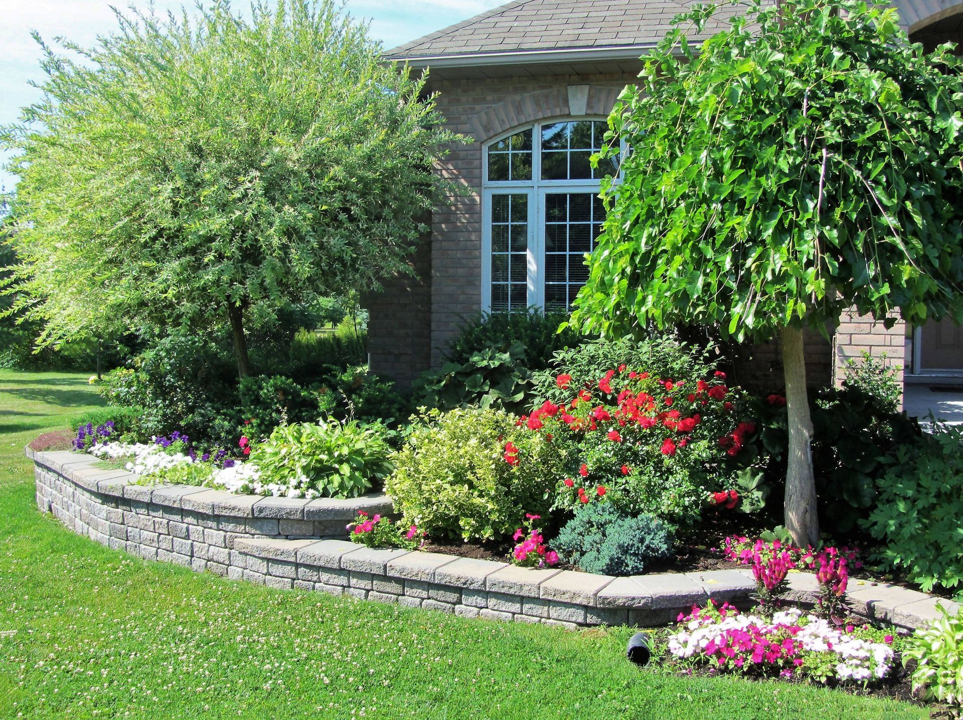 Front landscaping that include mulch, bushes, and landscaping trees