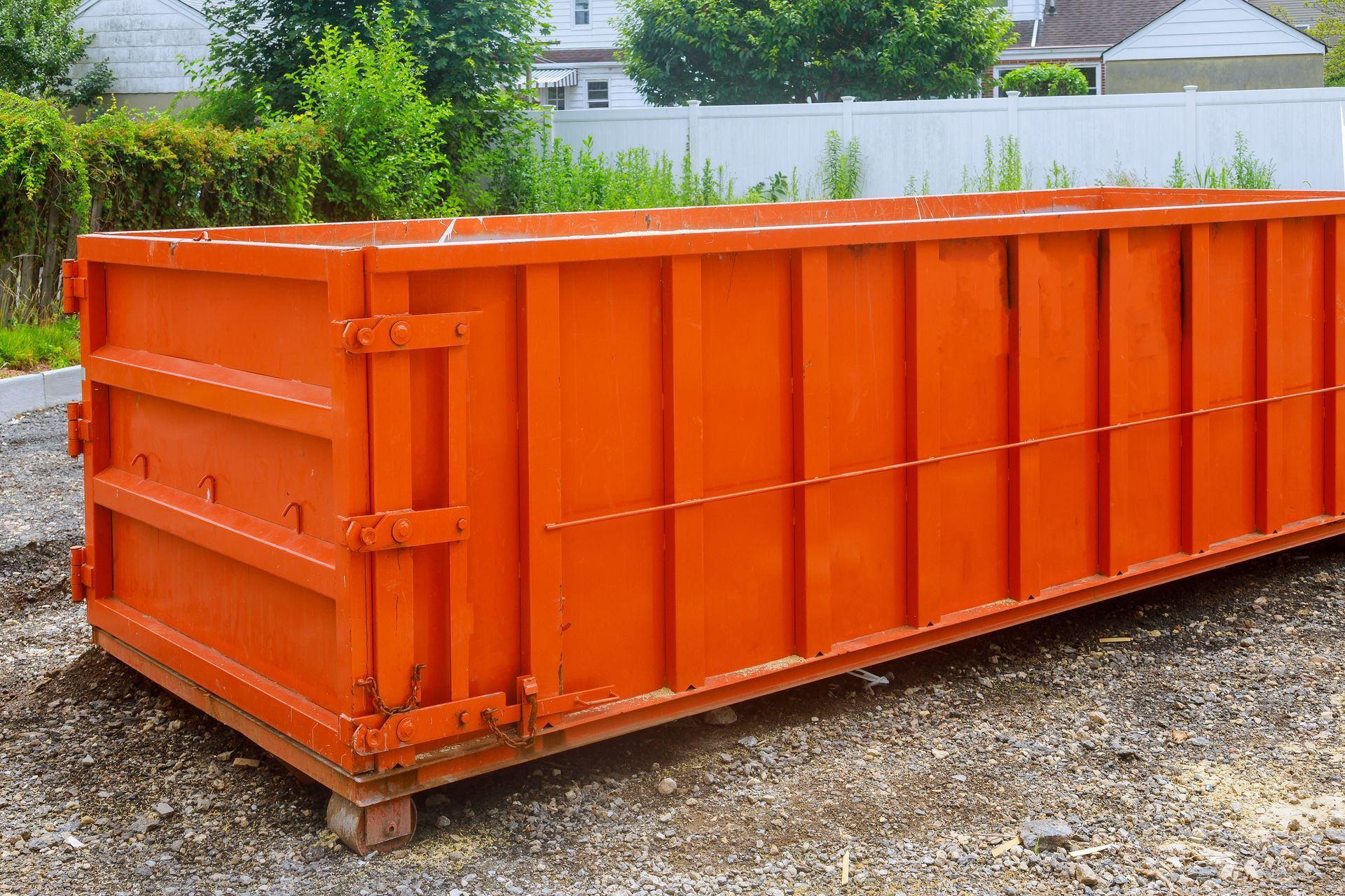 Large orange dumpster rental in Mishawaka, IN from Indiana Roll-Off Inc., placed on a gravel surface